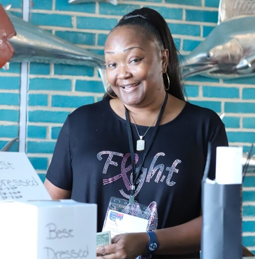 A lady standing at the raffle ticket counter.