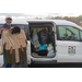 A man holding a coat by the donations in a van.