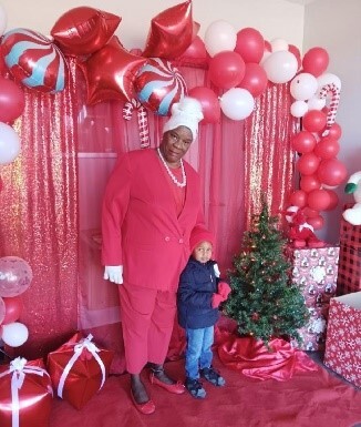 A woman and a child pose in front of a backdrop.