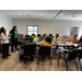 A woman gesturing with her hands as she speakers to a group of individuals.