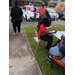 A group of individuals working on their posters while sitting at tables outside.