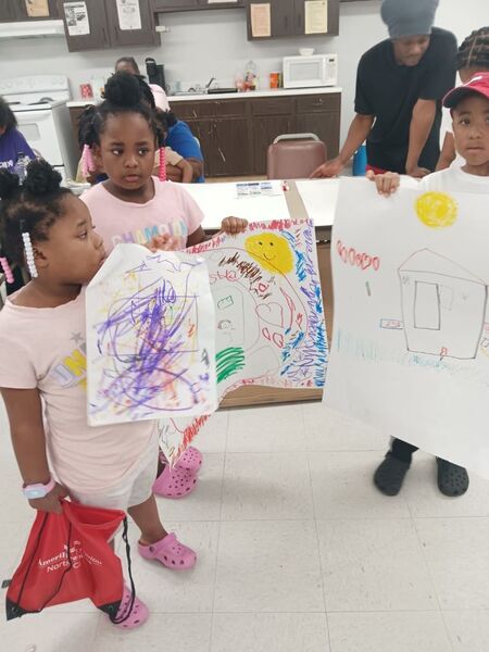 Three children posing with their posters.