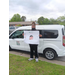 A boy posing with his poster in front of a white van.