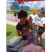 Kids getting school supplies from a table.