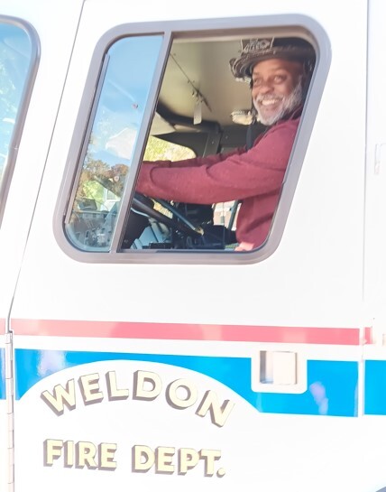 A man driving a Weldon Fire Department truck.