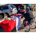 A person sitting in front of a table with a sign.