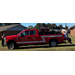 People sitting on the back of a red truck full of equipment.