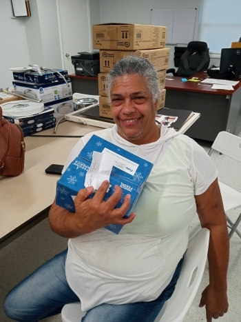 Lady sitting down holding a box at the food giveaway.